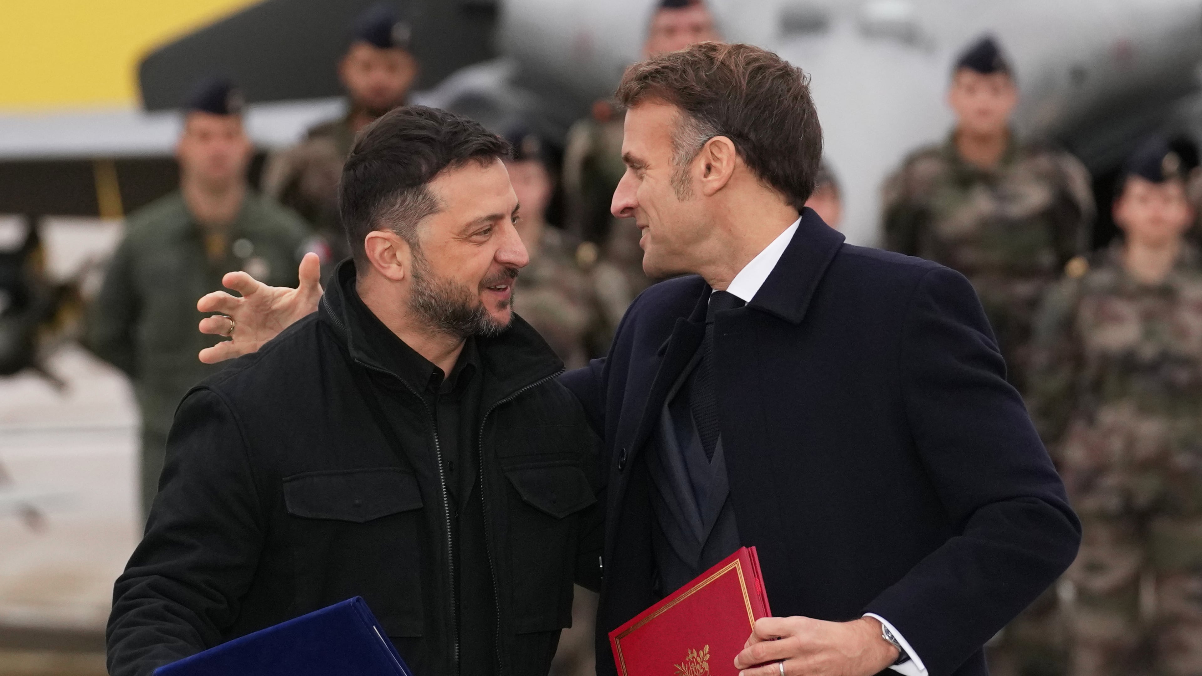 French President Emmanuel Macron, right, and Ukrainian President Volodymyr Zelenskyy hug after signing an agreement Monday, Nov. 17, 2025 at the Villacoublay air base near Paris. (AP Photo/Christophe Ena, Pool)