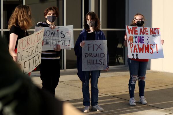 Druid Hills High students show their support for school renovations outside of a DeKalb County Board of Education meeting in April 2022, after school board members opted not to modernize the high school. Thanks to weeks of pressure and the intervention of state officials, the district committed to modernizing the aging school — but now more than two years later, the project has hit a major roadblock. (Jason Getz/AJC)