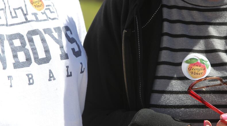 Voters brandish the stickers they are distributed after having voted in any election in the state of Georgia after casting their vote in the 6th district special election to replace Tom Price in Marietta, Georgia, on April 10, 2017. (HENRY TAYLOR / HENRY.TAYLOR@AJC.COM)