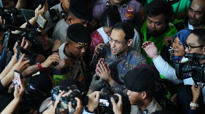 Fomer Education Minister Nadiem Anwar Makarim, center, who is also the co-founder of ride-hailing and payment giant Gojek, talks to the media after his sentencing hearing in a Google Chromebook laptop procurement corruption case, at the Corruption Court in Jakarta, Indonesia, Tuesday, June 30, 2026. (AP Photo/Tatan Syuflana)