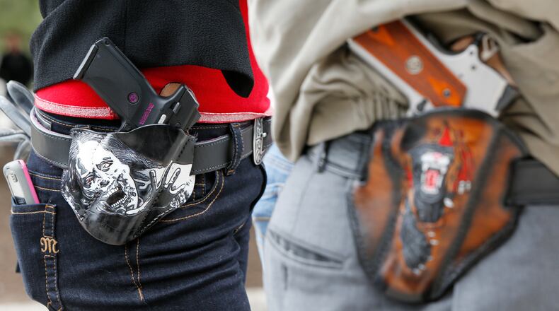 AUSTIN, TX - JANUARY 1: Art and Diana Ramirez of Austin with their pistols in custom-made holsters during and open carry rally at the Texas State Capitol on January 1, 2016 in Austin, Texas. On January 1, 2016, the open carry law takes effect in Texas, and 2nd Amendment activists hold an open carry rally. (Photo by Erich Schlegel/Getty Images)