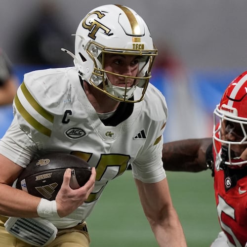 Georgia Tech quarterback Haynes King (10) runs against Georgia linebacker Raylen Wilson (5) during the first half of an NCAA college football game, Friday, Nov. 28, 2025, in Atlanta. (AP Photo/Mike Stewart)