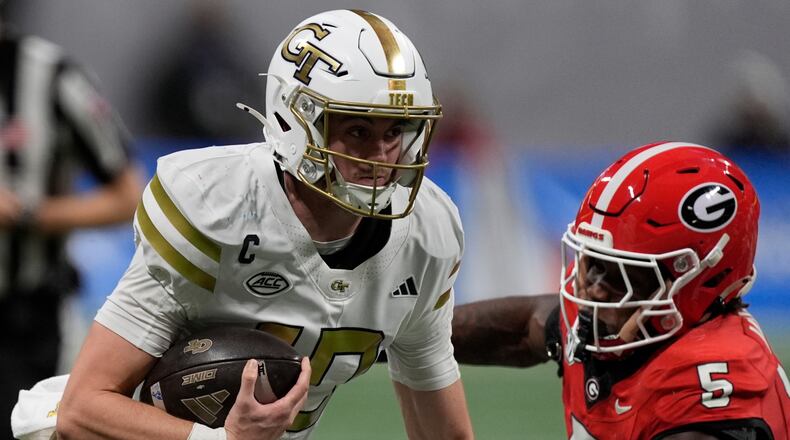 Georgia Tech quarterback Haynes King (10) runs against Georgia linebacker Raylen Wilson (5) during the first half of an NCAA college football game, Friday, Nov. 28, 2025, in Atlanta. (AP Photo/Mike Stewart)