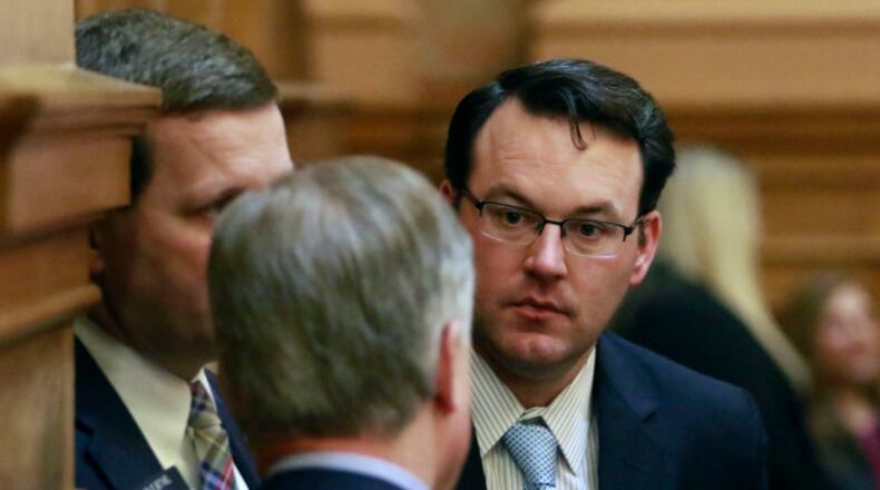 Sen. Burt Jones confers with colleagues on the floor. BOB ANDRES / BANDRES@AJC.COM