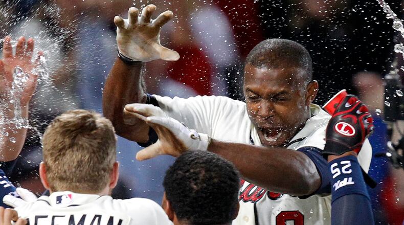 Atlanta Braves' Justin Upton, top right, is doused by teammates as he crosses home plate after hitting a walkoff home run during the ninth inning of a baseball game against the Chicago Cubs, Saturday, April 6, 2013, in Atlanta. Atlanta won 6-5. (AP Photo/Butch Dill)