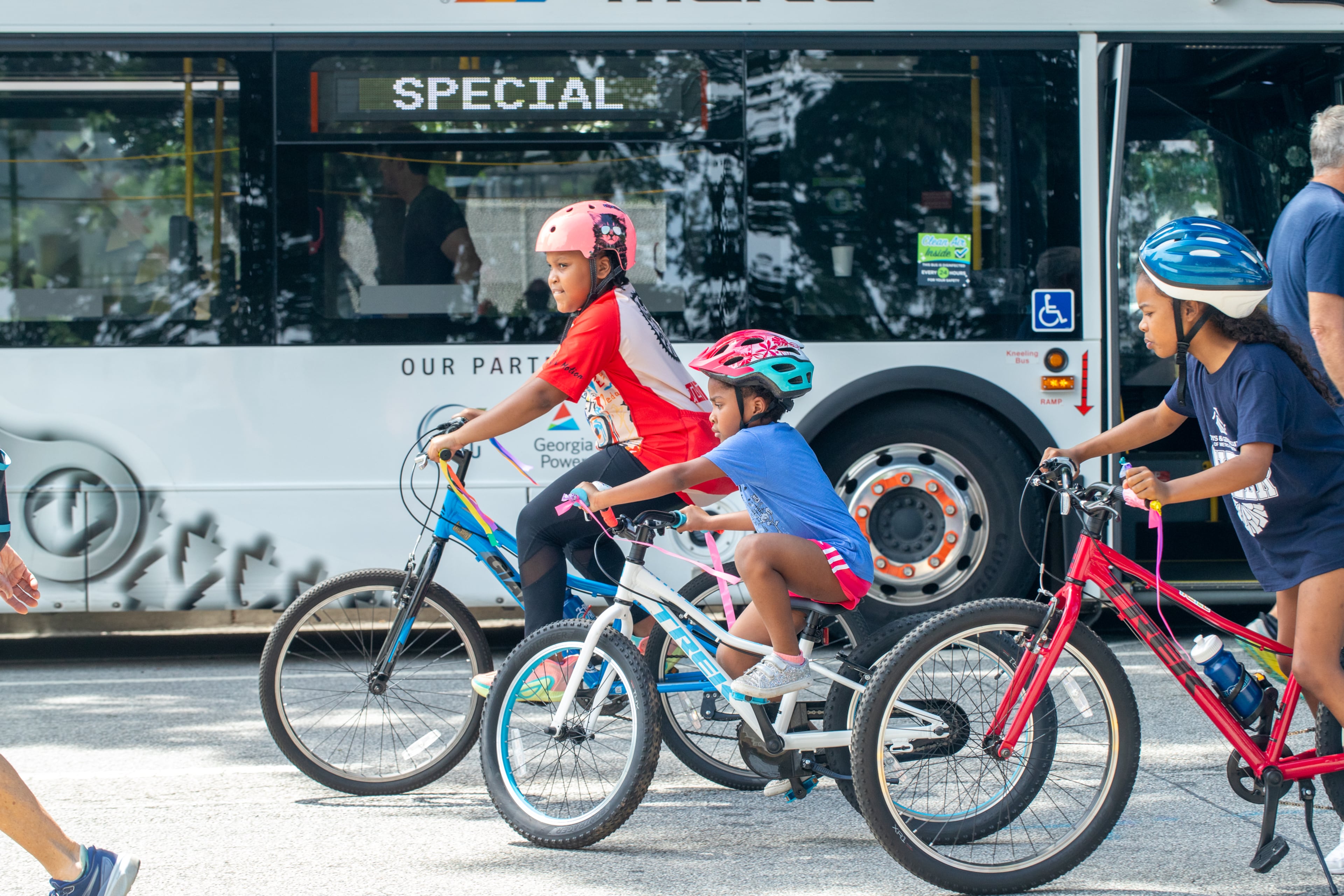 Safiyah Abdullah, 9, from left, Zena Abdullah, 5, and Mia Shorthouse, 9, take off after their break at the MARTA display during Atlanta Streets Alive on Sunday, April 27, 2025. The event shut down parts of Peachtree Street making way for bikers, walkers, small businesses and city resources (Jenni Girtman for The Atlanta Journal Constitution)