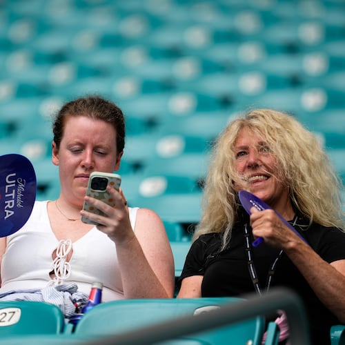 Spectators fan themselves before the World Cup quarterfinal soccer match between Norway and England in Miami Gardens, Fla., Saturday, July 11, 2026. (AP Photo/George Walker IV)
