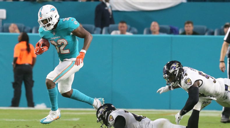 Miami Dolphins' Kenyan Drake (32) breaks away from Baltimore Ravens' Tony Jefferson (23) for a large gain to help set up a touchdown on Saturday, Aug. 25, 2018 at Hard Rock Stadium in Miami Gardens, Fla. (Charles Trainor Jr./Miami Herald/TNS)