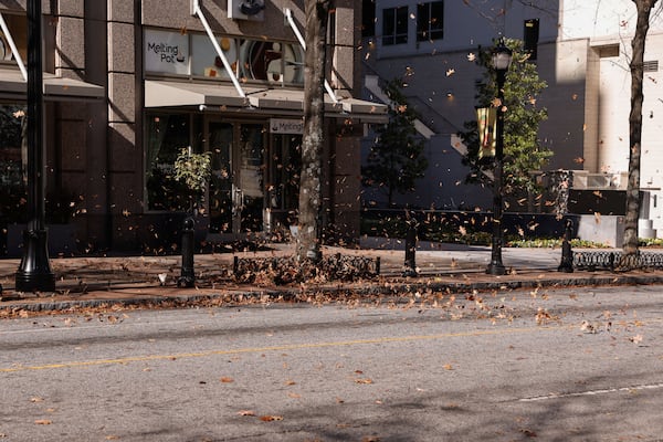On Monday, wind eddies picked up fallen leaves and carried them above Peachtree Street. (Natrice Miller/AJC)