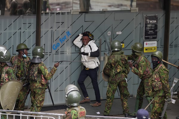 Police surround a demonstrator protesting on the one-year anniversary of deadly anti-tax demonstrations in Nairobi, Kenya, Wednesday, June 25, 20125. (AP Photo/Brian Inganga)