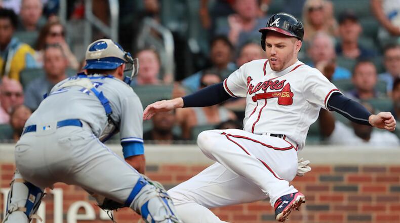 The Atlanta Braves' Freddie Freeman, right, scores past Toronto Blue Jays catcher Luke Maile on a Nick Markakis double in the second inning on Wednesday, July 11, 2018, at SunTrust in Atlanta. (Curtis Compton/Atlanta Journal-Constitution/TNS)