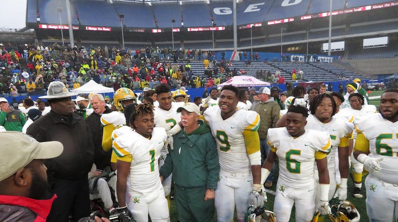 Dublin coach Roger Holmes is surrounded by Fighting Irish players following their 42-32 win over the Brooks County Trojans in the Class AA championship game on Friday, Dec. 13, 2019 at Georgia State Stadium. (Adam Krohn)