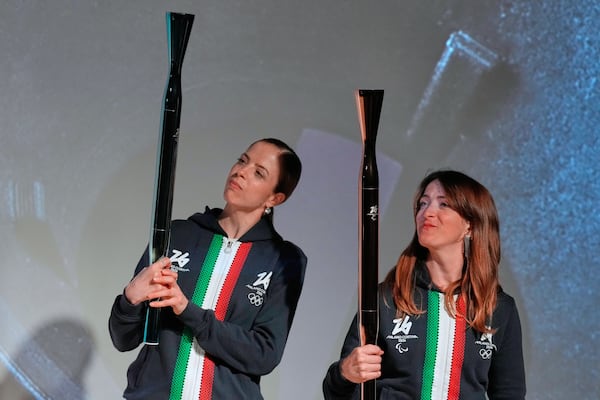Italian figure skaters, Carolina Kostner, left, and Valentina Marchei, right, hold the Torches for the Olympic and Paralympic Winter Games Milano Cortina 2026 during the official unveiling ceremony at Italian Pavilion of Osaka Expo 2025 in Osaka, western Japan, Monday, April 14, 2025. (AP Photo/Hiro Komae)