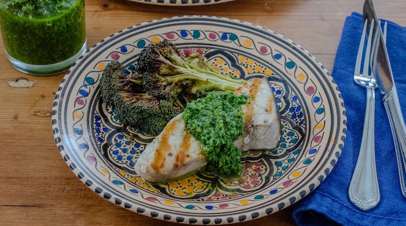 Grilled swordfish steak topped with zesty chermoula sauce, shown here with roasted broccoli, is an easy heart-healthy entree. (Virginia Willis for the AJC)