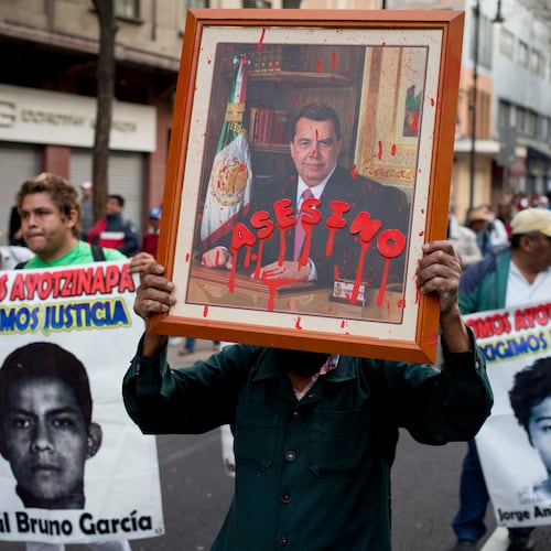 FILE - A protestor holds a portrait of Angel Aguirre, the former governor of Guerrero state, with the Spanish word for assassin written across it, during a march against the disappearance of 43 students from a rural teachers' college, Jan. 26, 2015, in Mexico City. (AP Photo/Eduardo Verdugo, File)