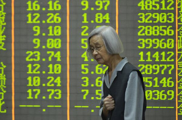 A stock investor stands in front of the stock price indices at a brokerage house in Hangzhou in eastern China's Zhejiang province, Monday, April 7, 2025. (Chinatopix Via AP)