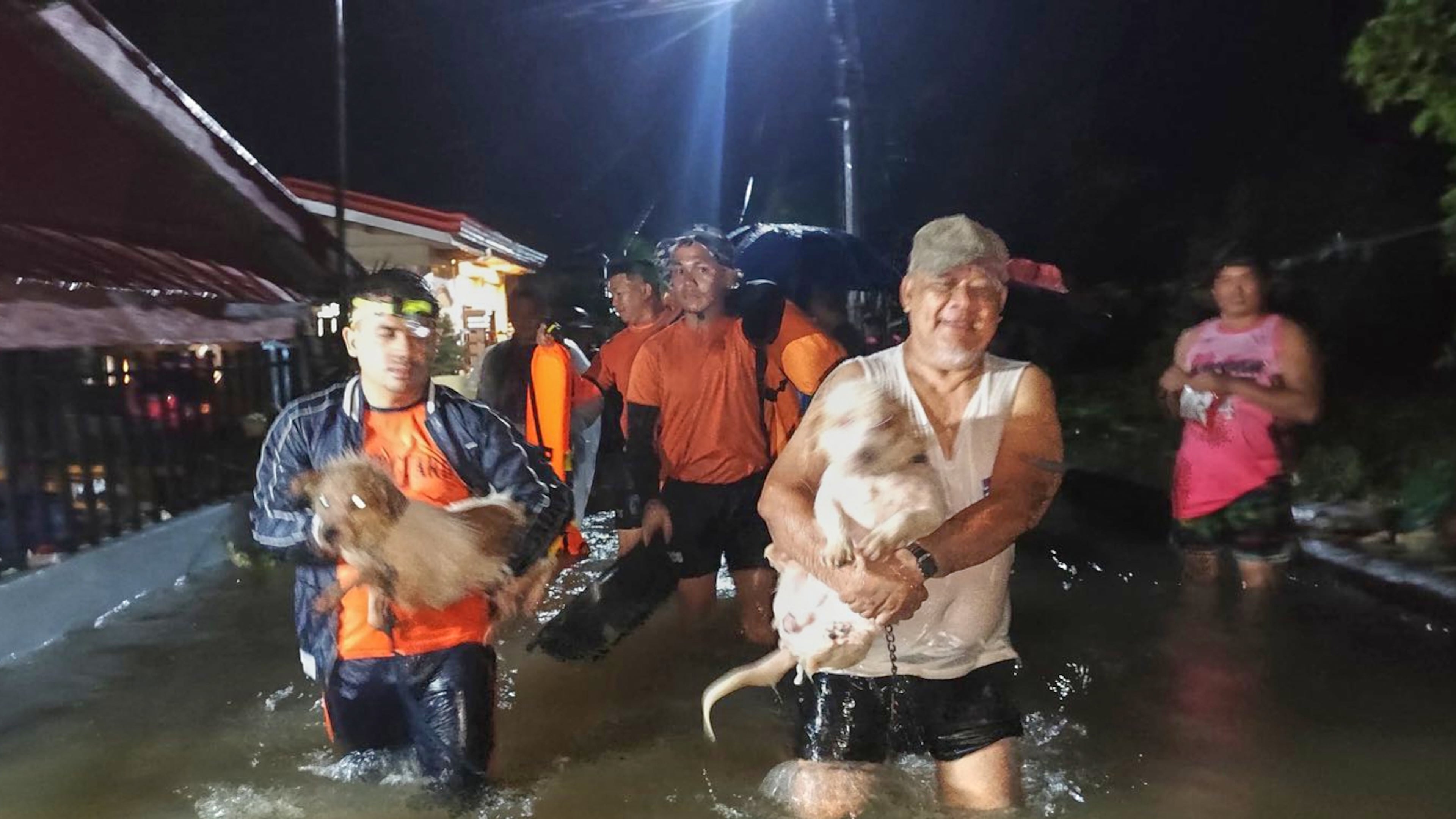 In this handout provided by the Philippine Coast Guard, residents and their dogs are evacuated by rescuers as floods rise due to Typhoon Bualoi in Ormoc, Leyte province, Philippines, on Friday Sept. 26, 2025. (Philippine Coast Guard via AP)