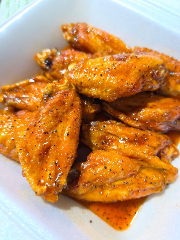 Vividly sauced hot wings on a square white plate