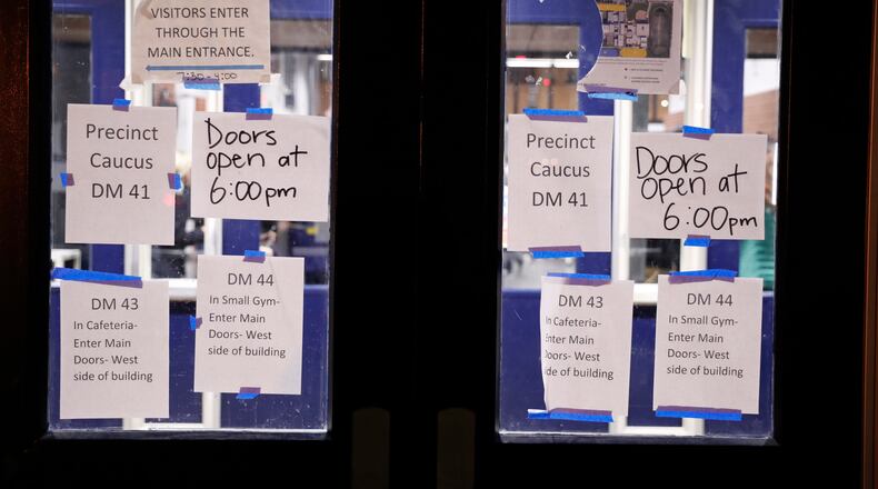 Directional signs are posted on doors at a caucus at Roosevelt Hight School, Monday, Feb. 3, 2020, in Des Moines, Iowa. (AP Photo/Andrew Harnik)