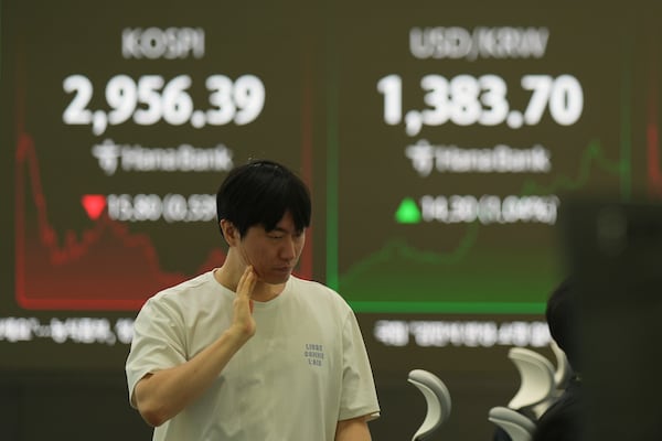 A dealer walks past near the screens showing the Korea Composite Stock Price Index (KOSPI), left, and the foreign exchange rate between U.S. dollar and South Korean won at a dealing room of Hana Bank in Seoul, South Korea, Thursday, June 19, 2025. (AP Photo/Lee Jin-man)