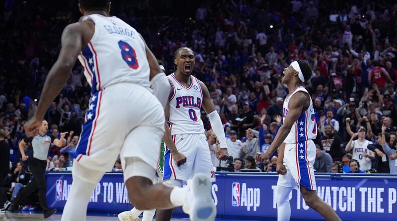 Philadelphia 76ers' Tyrese Maxey (0), Vj Edgecombe (77) and Paul George (8) celebrate during the second half of Game 6 in a first-round NBA basketball playoff series against the Boston Celtics Thursday, April 30, 2026, in Philadelphia. (AP Photo/Matt Slocum)