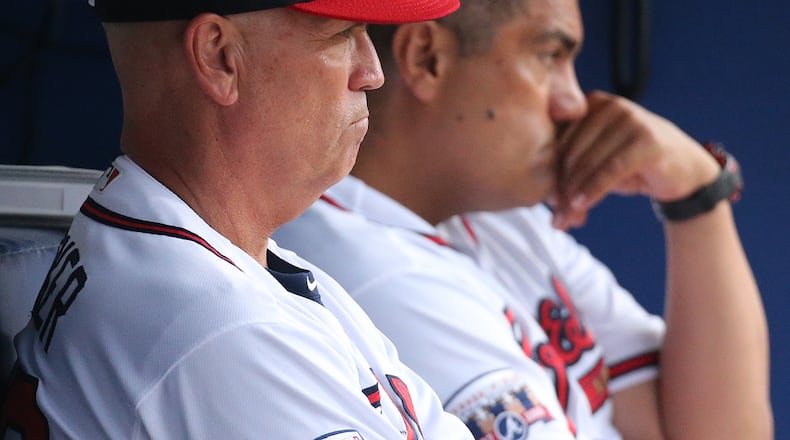 Braves first-base coach Eddie Perez (right) and manager Brian Snitker look on from the dugout during a game at Turner Field this past season. (Curtis Compton / ccompton@ajc.com)