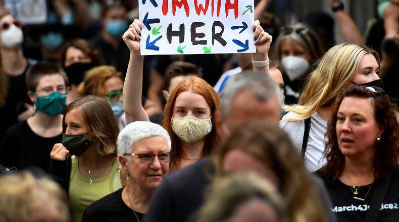 People hold up placards during a "March 4 Justice" rally against sexual violence and gender inequality in Melbourne on Feb. 27, 2022. (WILLIAM WEST/AFP via Getty Images/TNS)