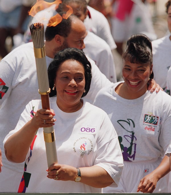 Coretta Scott King carries the Olympic torch Friday, July 19, 1996 prior to the 1996 Summer Olympic Games in Atlanta, Georgia. King carried the torch, then passed it to her son Dexter in front of King Chapel at Morehouse College. (Cox staff photo/Greg Lovett) 07/19/96