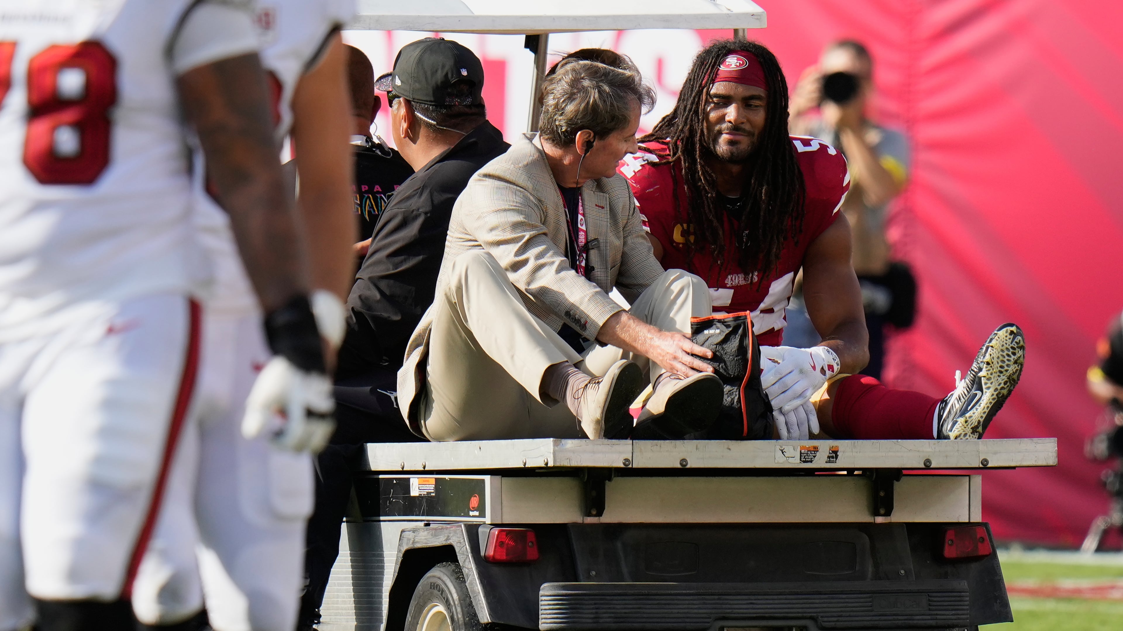 San Francisco 49ers middle linebacker Fred Warner, right, is carted off the field during the first half of an NFL football game against the Tampa Bay Buccaneers in Tampa, Fla., Sunday, Oct. 12, 2025. (AP Photo/Chris O'Meara)