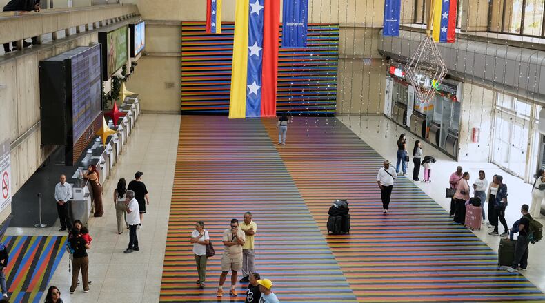 Travelers wait in the main hall of the Simon Bolivar Maiquetia International Airport in Maiquetia, Venezuela, Sunday, Nov. 13, 2025, after several international airlines canceled flights following a warning from the U.S. Federal Aviation Administration about a hazardous situation in Venezuelan airspace. (AP Photo/Ariana Cubillos)