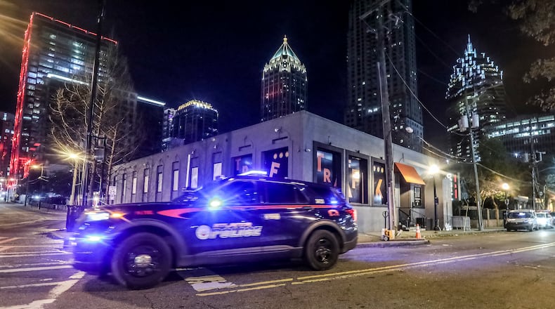 An Atlanta police patrol car drives by Traffik Kitchen and Cocktails nightclub on Friday, Jan. 28, 2022. (John Spink / John.Spink@ajc.com)