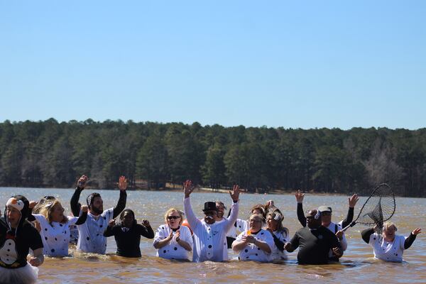Members of the Cobb County Sheriff's Office pose for pictures while standing waist-deep in the icy water of Lake Acworth. (Courtesy of Aleks Gilbert/Marietta Daily Journal)
