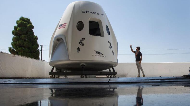 A reporter takes a smart phone photo of a mock up of the Crew Dragon spacecraft during a media tour of SpaceX headquarters and rocket factory on August 13, 2018 in Hawthorne, California. SpaceX plans to use the spaceship Crew Dragon, a passenger version of the robotic Dragon cargo ship, to carry NASA astronauts to the International Space Station for the first time since the Space Shuttle program was retired in 2011.