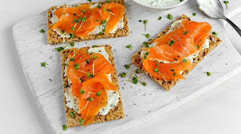 Homemade Crispbread toast with Smoked Salmon, Melted Cheese and cress salad. on white wooden board.