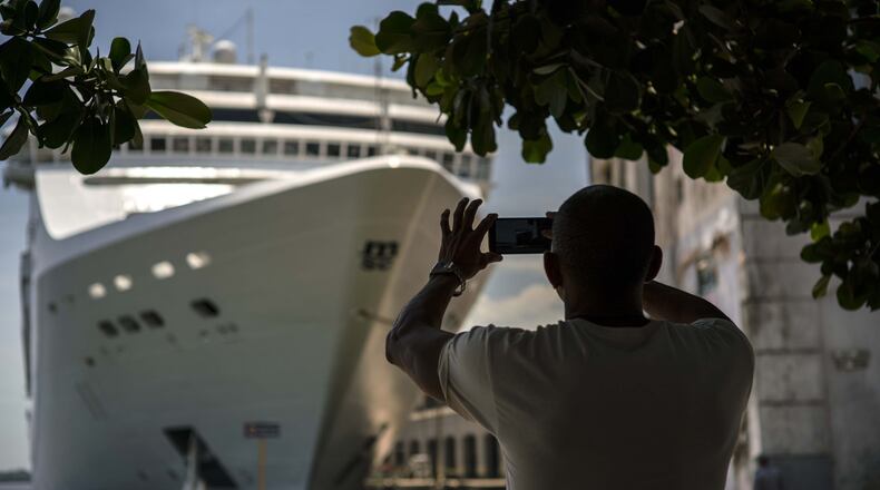 FILE - In this June 17, 2017, file photo, a man takes a photo of a cruise ship in Havana harbor, Cuba. President Donald Trump announced a new policy in June that partially rolled back the recent diplomatic opening with Cuba. New regulations implementing that policy are being unveiled Wednesday. (AP Photo/Ramon Espinosa, File)