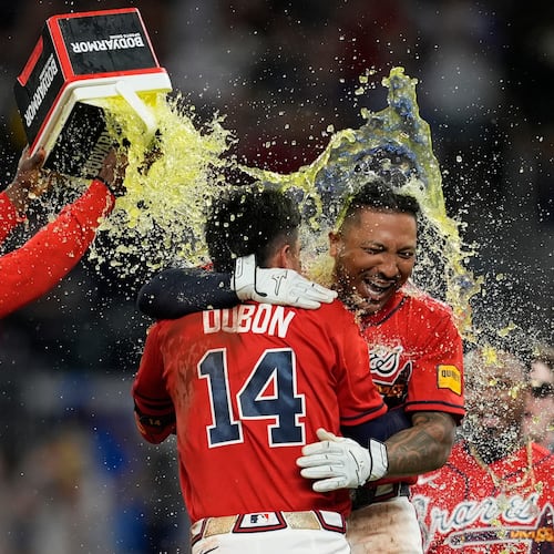 Atlanta Braves' Chadwick Tromp embraces Mauricio Dubón (14) after hitting the game-winning RBI-Single in the 11th inning of a baseball game against the Washington Nationals, Friday, May 22, 2026, in Atlanta. (AP Photo/Mike Stewart)