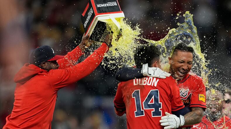Atlanta Braves' Chadwick Tromp embraces Mauricio Dubón (14) after hitting the game-winning RBI-Single in the 11th inning of a baseball game against the Washington Nationals, Friday, May 22, 2026, in Atlanta. (AP Photo/Mike Stewart)