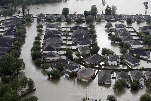 Homes are surrounded by floodwaters from in Spring, Texas. Doing an inventory of all of your possessions while your home is safe and sound makes it easier to file an insurance claim after a disaster such as Hurricane Harvey. (AP Photo/David J. Phillip)