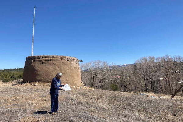 In this photo provided by researchers, Clifford Tsosie stands in front of the Round House in Picuris Pueblo, N.M., in April 2024. It is one of the Picuris' ritual rooms, used by members of the summer and winter society for rituals and meetings. (Thomaz Pinotti via AP)