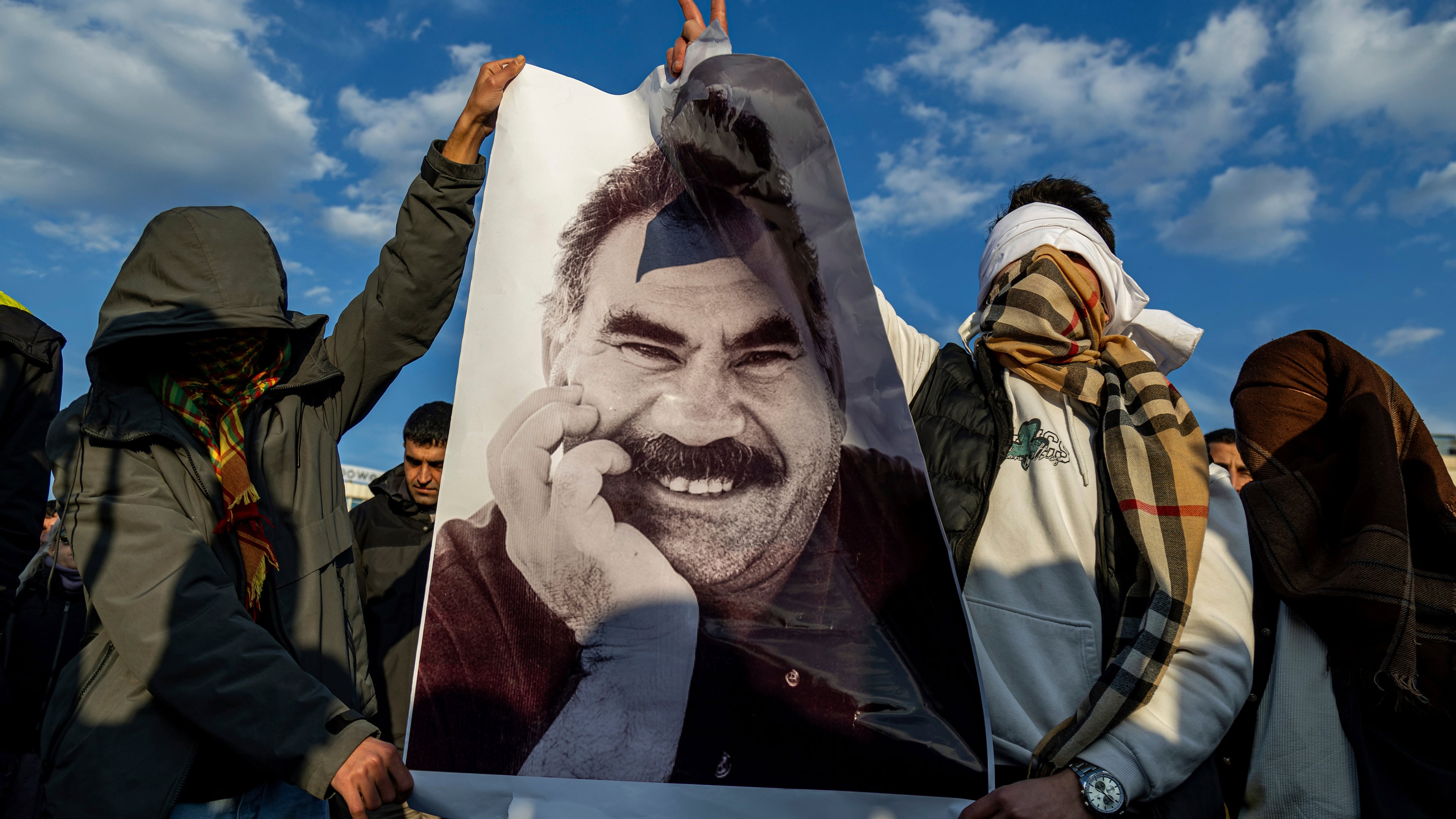 FILE - Youngsters hold a photograph of Abdullah Ocalan, the jailed leader of the militant Kurdish group, or PKK, in Diyarbakir, Turkey, Feb. 27, 2025. (AP Photo/Metin Yoksu, File)
