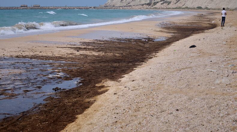 Dark oil residue covers parts of the shoreline at Shib Deraz Beach on Qeshm Island, Iran, Thursday, Aug. 13, 2026, amid ongoing wartime attacks on vessels and infrastructure in and around the Strait of Hormuz, though the spill’s source has not been independently determined. (Amirhosein Khorgooei/ISNA)