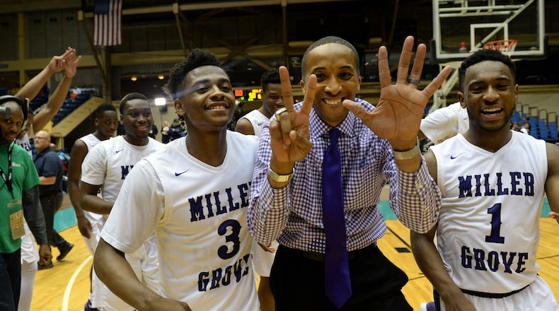 Miller Grove Wolverines head coach Sharman White holds up 7 fingers for their 7th championship win. He's flanked by Alterique Gilbert (3)j. KENT D. JOHNSON/ kdjohnson@ajc.com