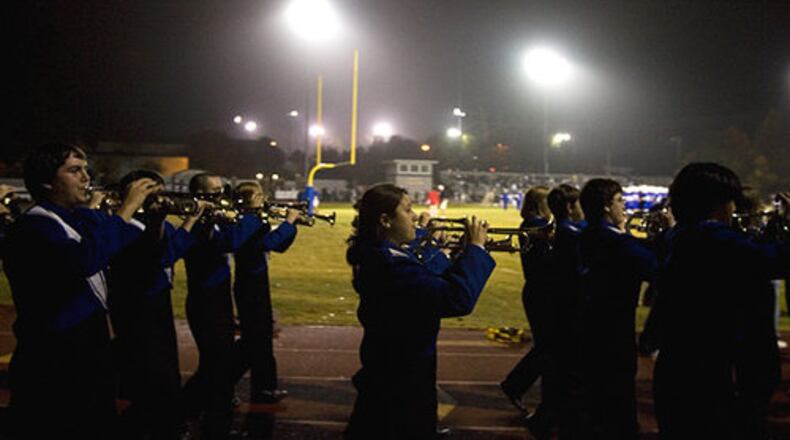 The Walton High School marching band enters Raider Valley before the start of the game.