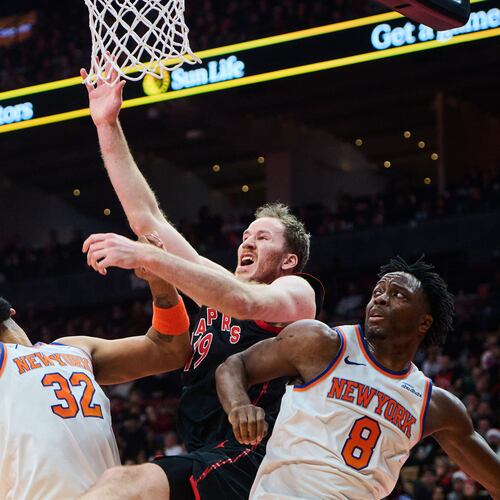 Toronto Raptors' Jakob Poeltl (19) is stopped at the net by New York Knicks' Karl-Anthony Towns (32) and New York Knicks' OG Anunoby (8) during the first half of an NBA Cup basketball game in Toronto, Tuesday, Dec. 9, 2025. (Sammy Kogan/The Canadian Press via AP)