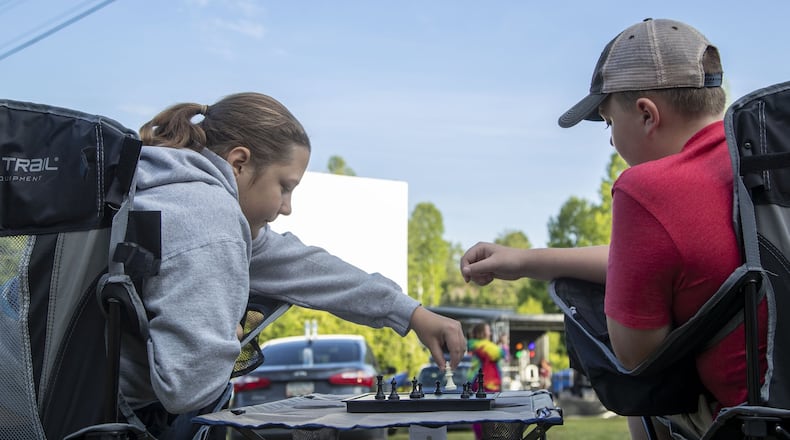 Tiger, Georgia - Siblings Tillie Crumley, 16, (left) and Shepard Crumley, 11, (right) play a game of chess before the start of the movie at the Tiger Drive-In movie theater in Tiger, Friday, May 22, 2020. This was the family’s first time at the theater. (ALYSSA POINTER / ALYSSA.POINTER@AJC.COM)