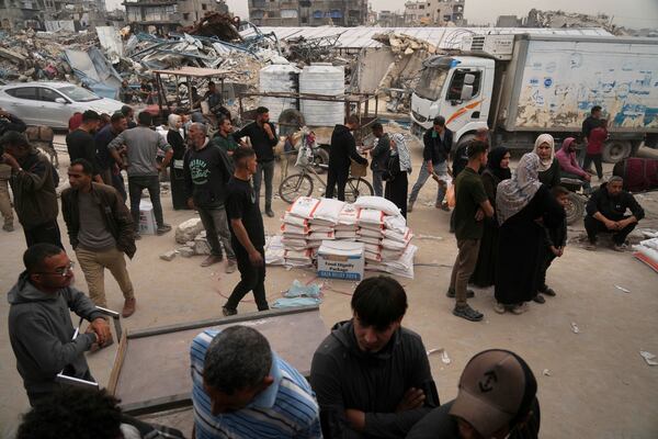 Palestinians receive bags of flour and other humanitarian aid distributed by UNRWA, the U.N. agency helping Palestinian refugees in Jabaliya, Gaza Strip on Tuesday, April 1, 2025. (AP Photo/Jehad Alshrafi)