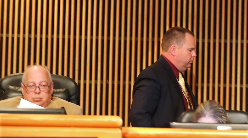 Tommy Hunter (right), the District 3 leader that recently called U.S. Rep. John Lewis a “racist pig” on Facebook, walks out just before public comments as more protesters demand his resignation during the Gwinnett County Board of Commissioners public hearing session Tuesday. Curtis Compton/ccompton@ajc.com