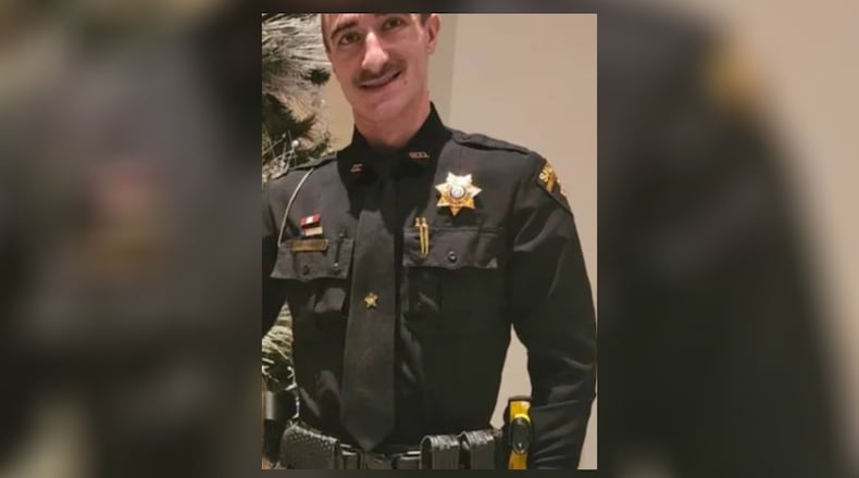 Towns County sheriff's Deputy Austin Bradburn was shot while he struggled over his own gun with a man he'd pulled over in a traffic stop, the GBI said.