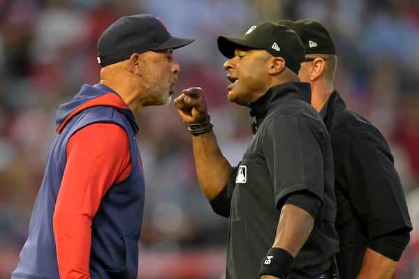 Boston Red Sox manager Alex Cora, left, argues with umpire Alan Porter, front right, as umpire Jim Wolf, back right, looks on after he was ejected in the fifth inning during a baseball game against the Los Angeles Angels, Monday, June 23, 2025, in Anaheim, Calif. (AP Photo/Jayne Kamin-Oncea)