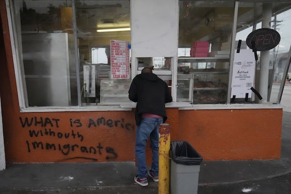 A man views a vandalized donut shop Sunday, June 8, 2025, in Compton, Calif., following an immigration raid protest the night before. (AP Photo/Jae Hong)